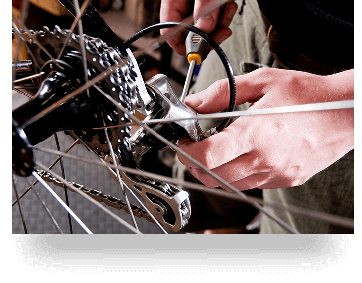 Male mechanic working in bicycle repair shop using tools